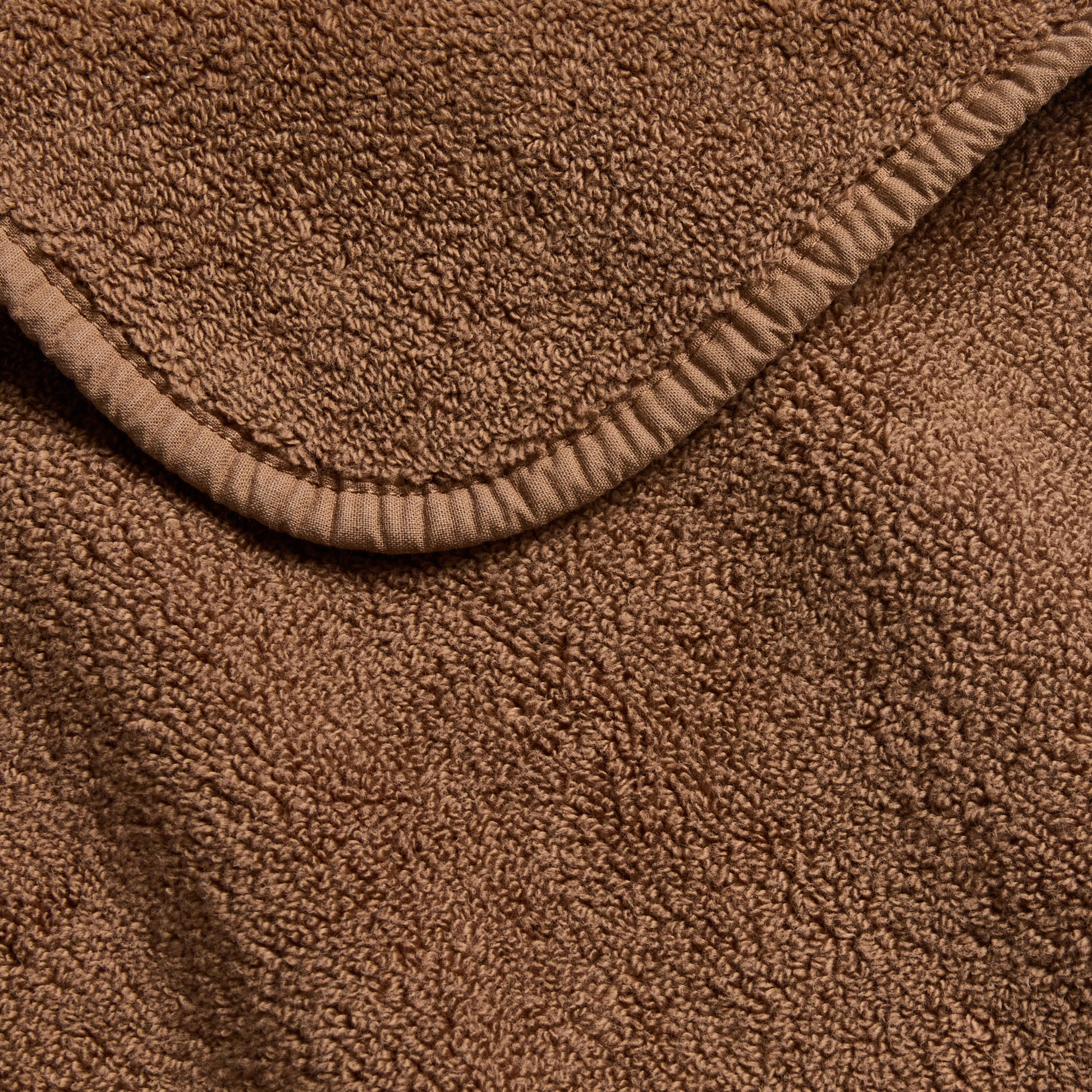 Coffee brown signature bath towel with a soft, plush terry texture and a neatly finished stitched hem border.