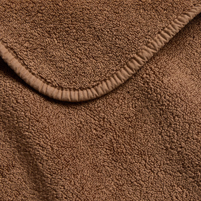 Coffee brown signature bath towel with a soft, plush terry texture and a neatly finished stitched hem border.