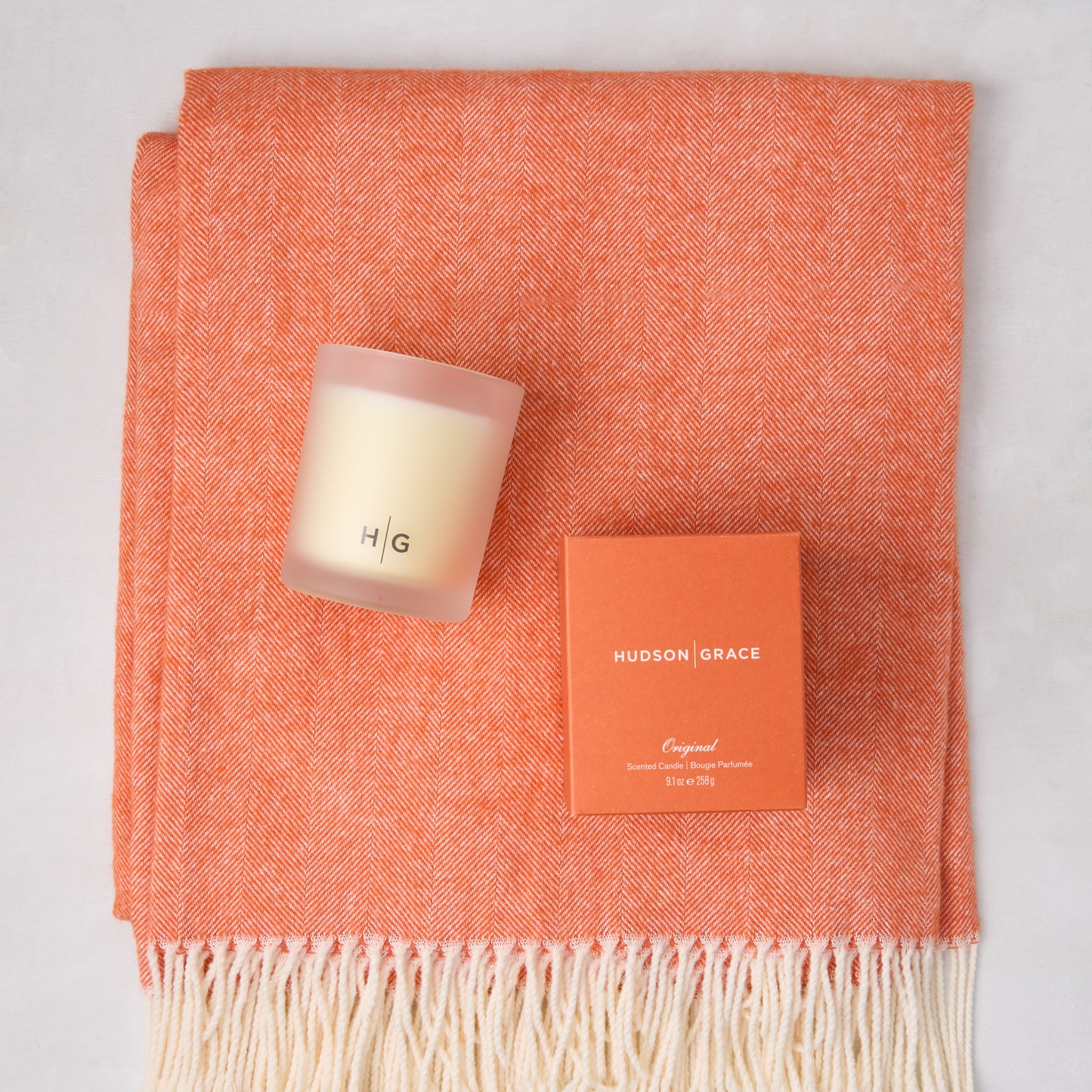 HG Comfy Day Bundle: Mandarin orange Italian herringbone throw with fringe, HG scented candle, and candle box.