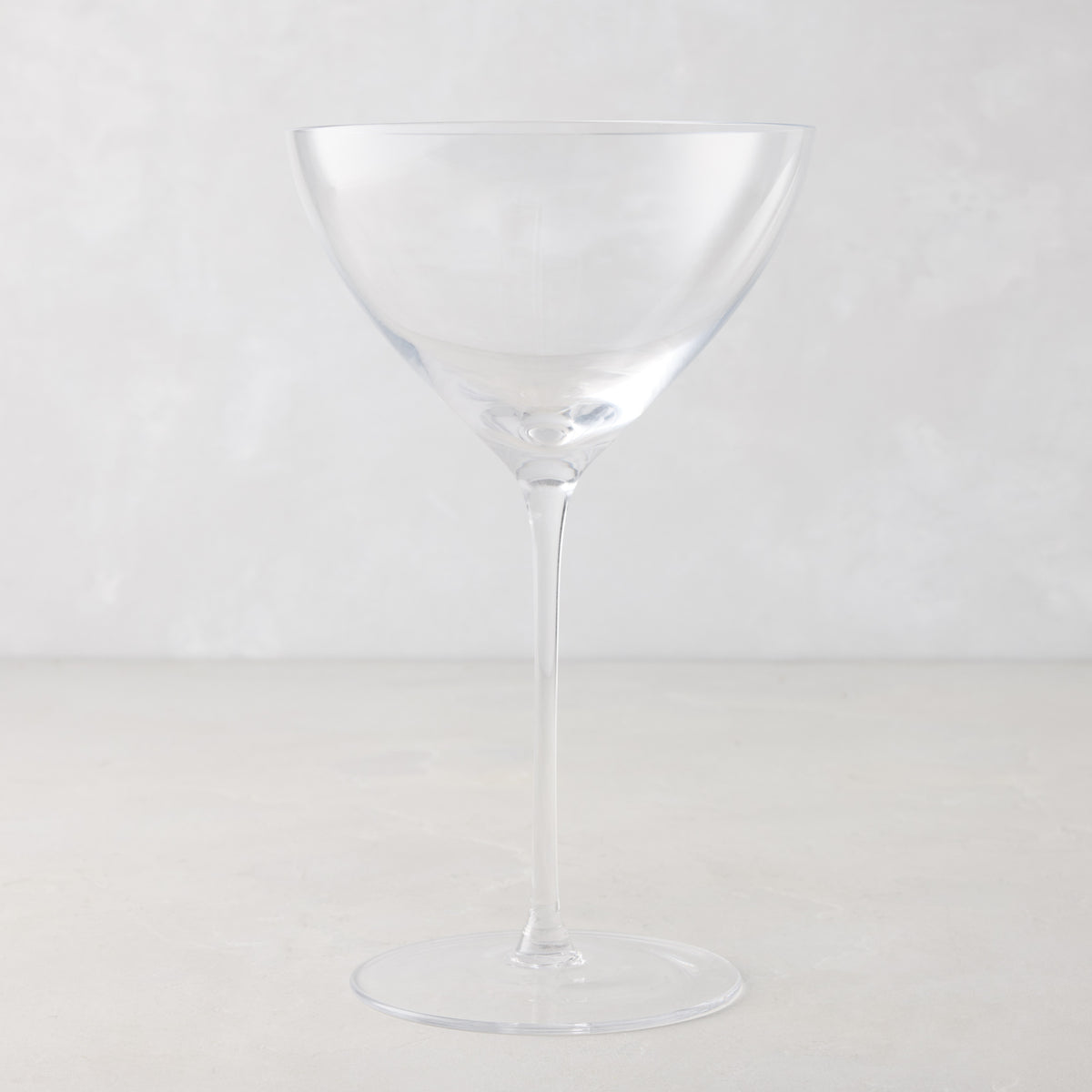 Oversized 14oz mouth-blown clear glass martini glass with a tall, slender stem on a light gray background.