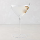 Oversized 14oz mouth-blown clear glass martini glass with a long stem and a single olive garnish.