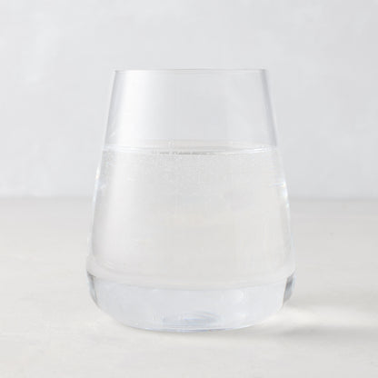 Clear HG Heritage Stemless Glass, mouth-blown, filled with water, on a light background.