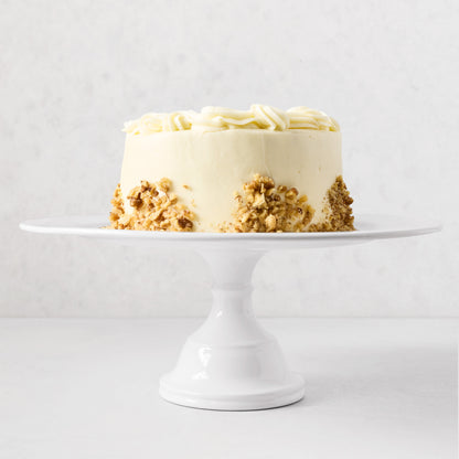 HG Original Large Pedestal Cake Stand, creamy white ceramic, 16"Dia x 6.5"H, holding a cake.