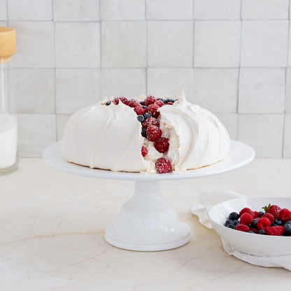 HG Original Medium Pedestal Cake Stand, creamy white ceramic, 13" diameter, 5.5" H, holding a pavlova.