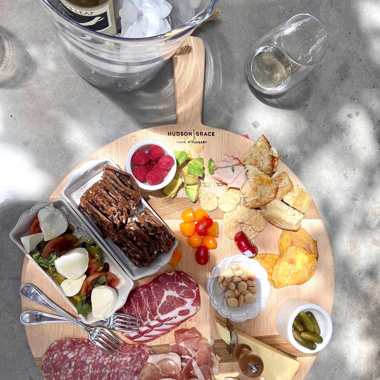 Round HG Reclaimed Wood Serving Board, 19.5"Dia, laden with charcuterie, cheese, fruit, and snacks.