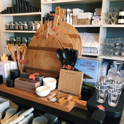 Three round HG Reclaimed Wood serving boards in varying sizes, displayed with kitchenware.