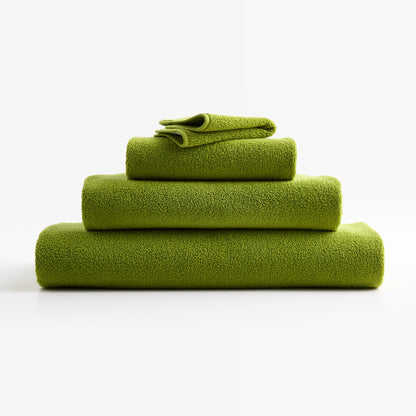 Stack of soft, aloe green zero-twist cotton hand towels with piped edges, made in Portugal.