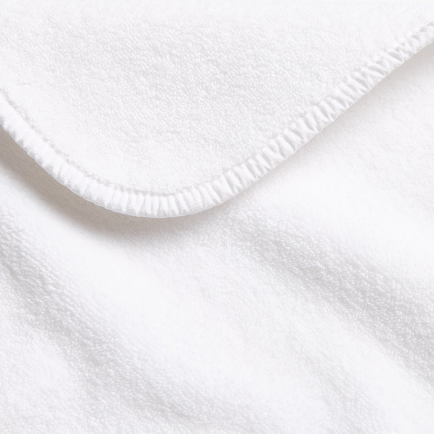 Cloud white Signature bath towel with a soft, plush cotton texture and a neatly finished stitched hem.