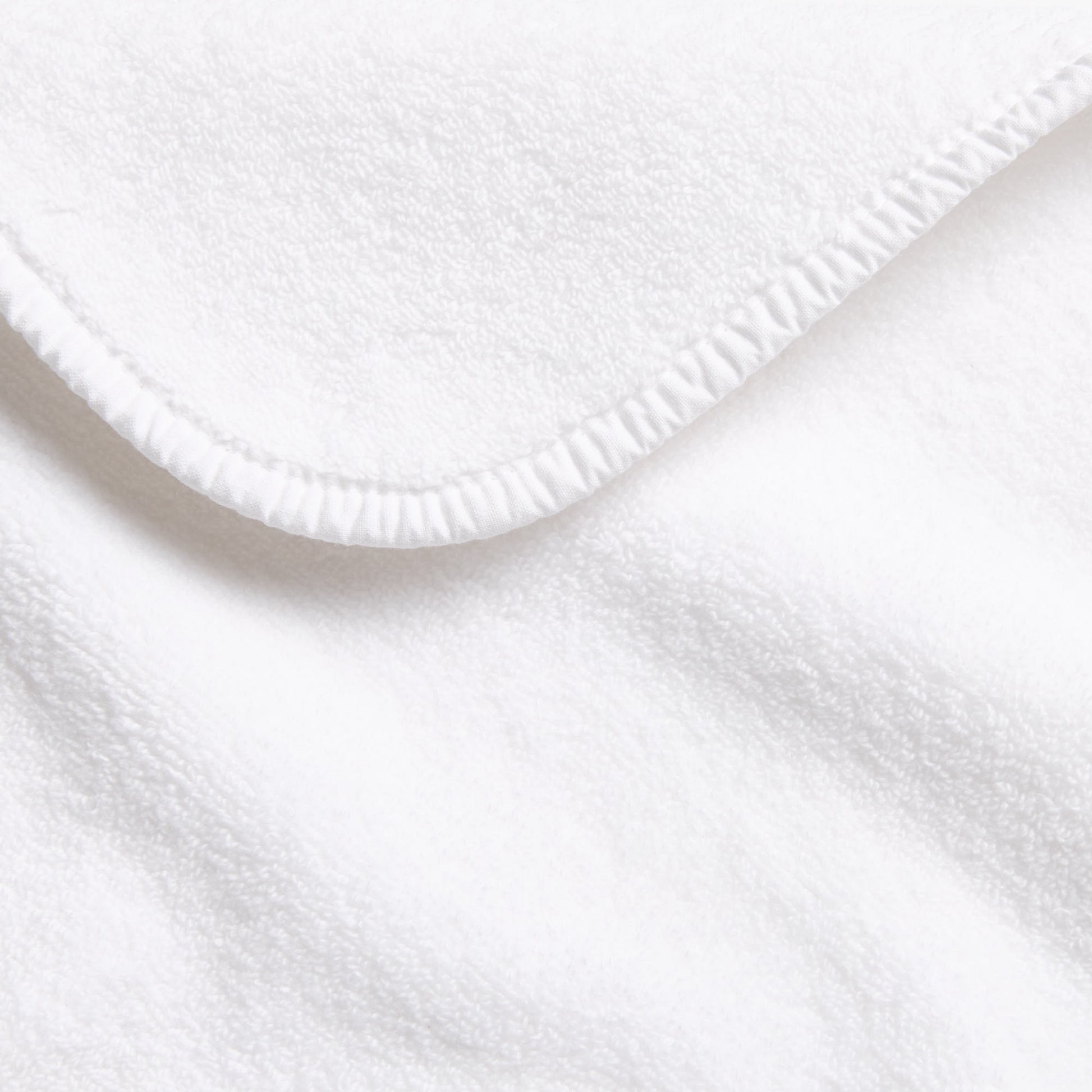 Cloud white Signature bath towel with a soft, plush cotton texture and a neatly finished stitched hem.