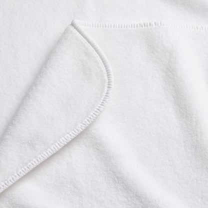 Cloud white Signature bath towel with a soft, plush cotton texture and a neatly finished rounded corner hem.