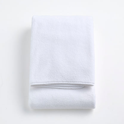 Folded cloud white signature bath towel made of plush, absorbent cotton fabric on a white background.