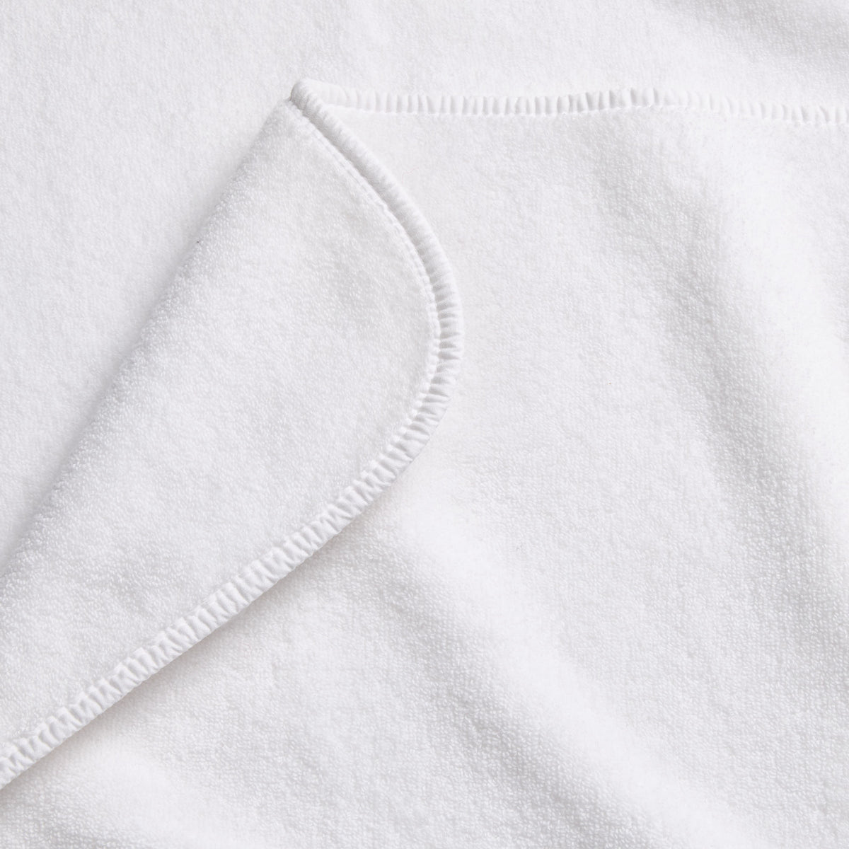 Cloud white Signature bath sheet featuring soft cotton terry fabric with a clean, rounded stitched hem edge.