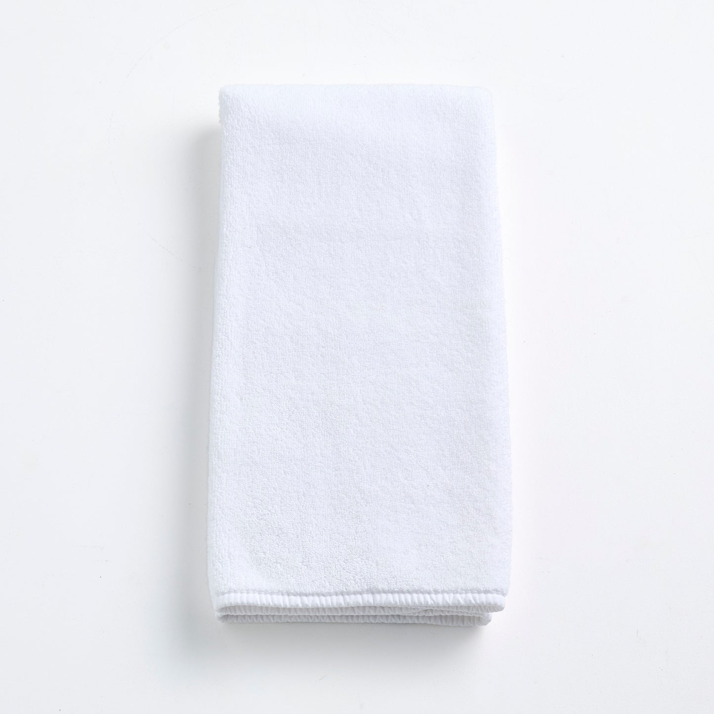 Cloud white Signature hand towel made of soft, folded cotton terry fabric on a clean white background.