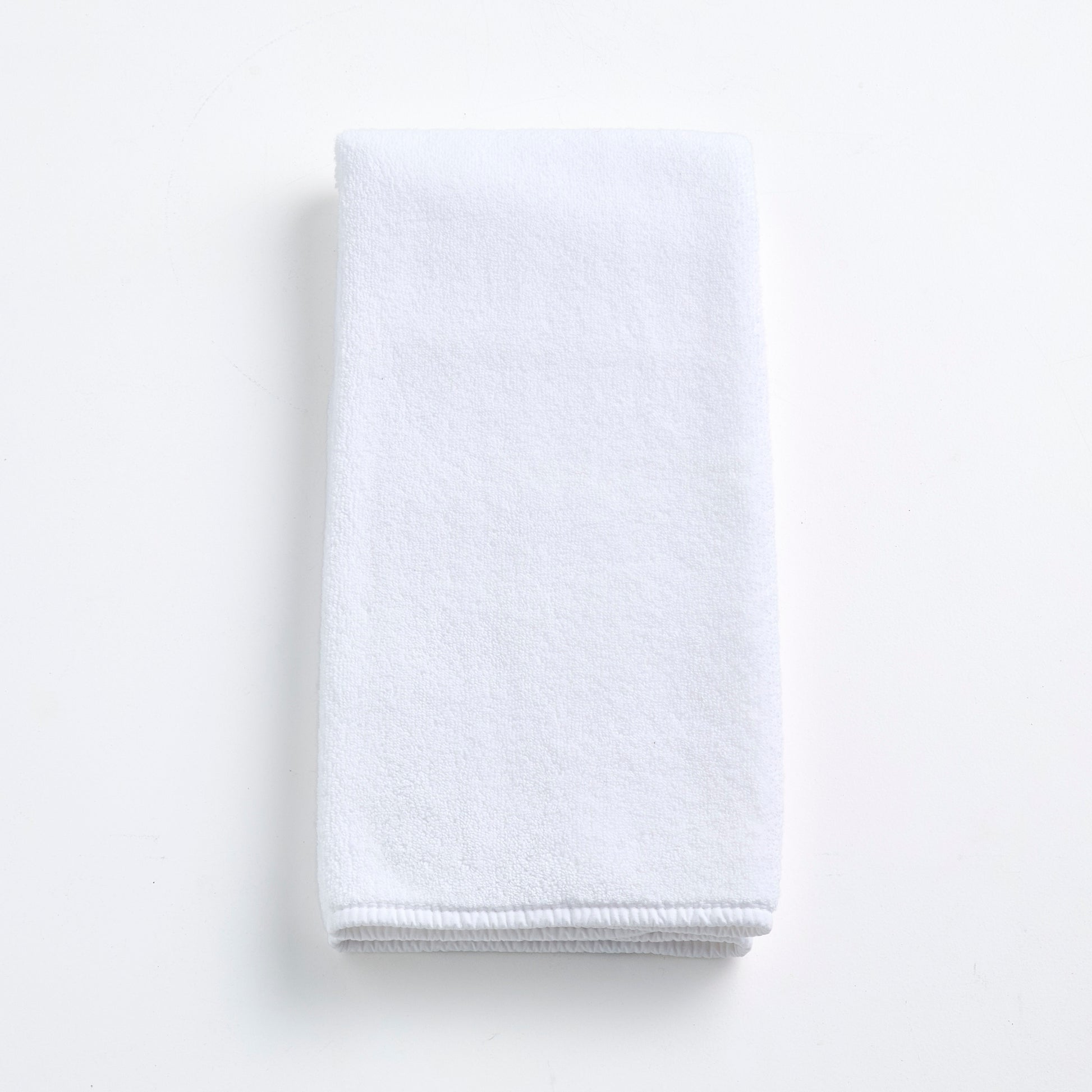 Cloud white Signature hand towel made of soft, folded cotton terry fabric on a clean white background.