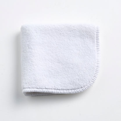 Cloud white Signature washcloth in soft, absorbent terry cotton with rounded corners and a finished piped edge.