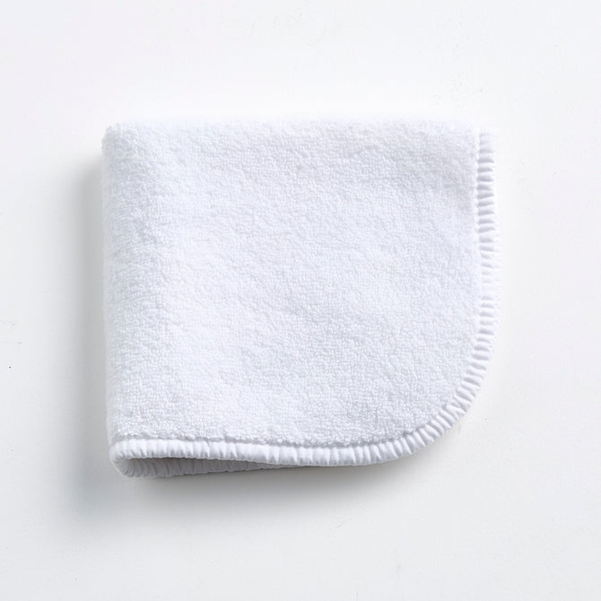 Cloud white Signature washcloth in soft, absorbent terry cotton with rounded corners and a finished piped edge.