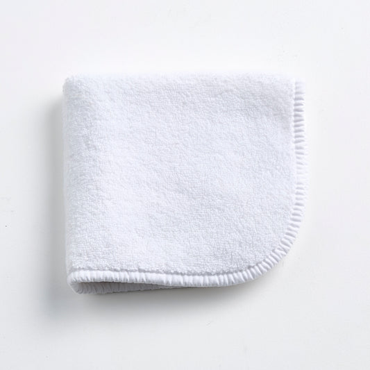 Cloud white Signature washcloth in soft, absorbent terry cotton with rounded corners and a finished piped edge.