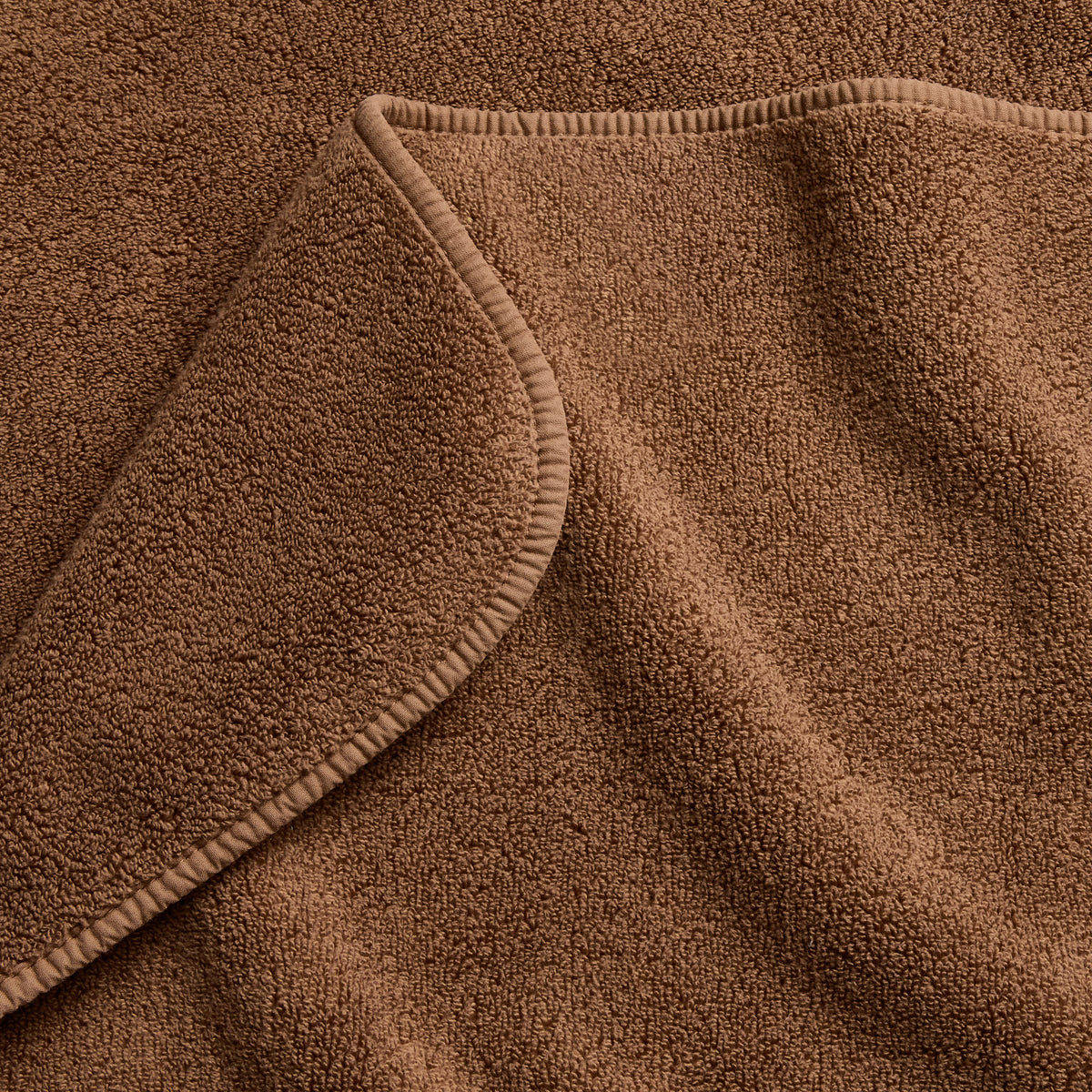 Coffee brown Signature bath sheet with a soft, plush terry texture and a neatly finished stitched edge.