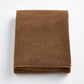 Folded coffee brown cotton bath sheet with a soft, plush texture and finished hem on a white background.