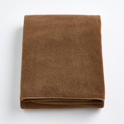 Folded coffee brown cotton bath sheet with a soft, plush texture and finished hem on a white background.