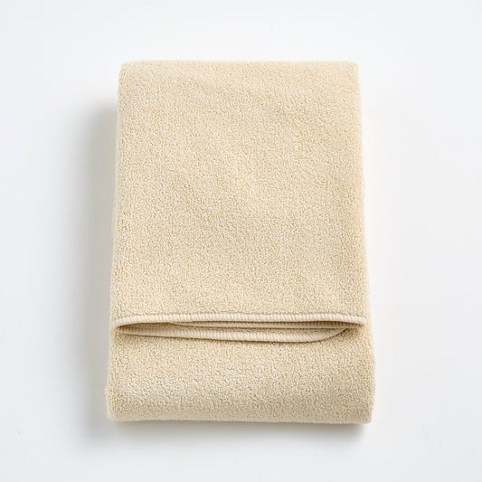 Folded Signature bath towel in creme brulee beige with a plush, textured cotton weave and finished edges.