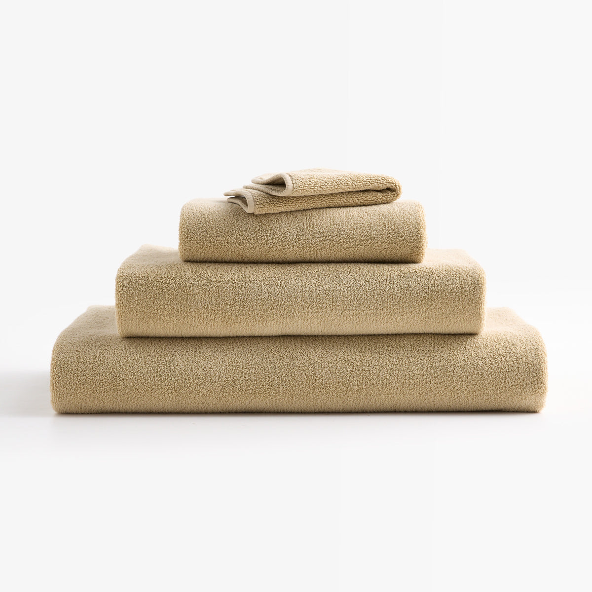 Stacked HG Signature Crème Brûlée zero-twist cotton bath sheets with piped edges in a soft beige hue.