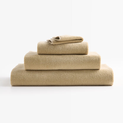 Stacked HG Signature Crème Brûlée zero-twist cotton bath sheets with piped edges in a soft beige hue.
