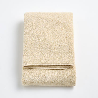 Folded Signature bath towel in creme brulee beige with a plush, textured cotton weave and finished edges.