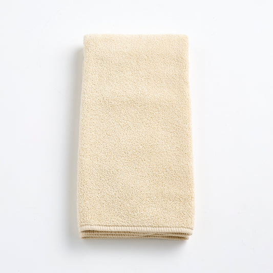 Folded creme brulee signature hand towel in soft, textured cotton terry cloth on a white background.