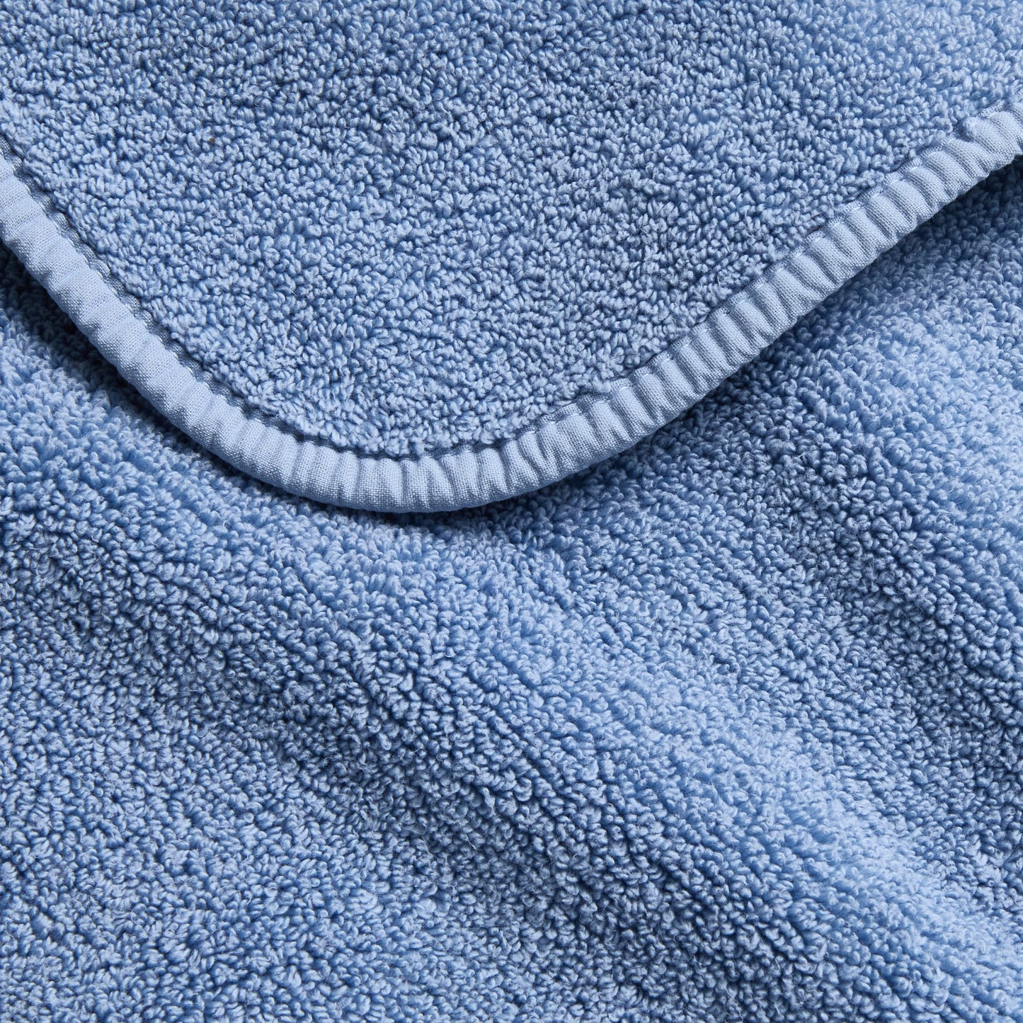 Denim blue Signature bath sheet with a soft, plush terry texture and a neatly finished fabric-bound edge.