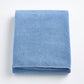 Folded denim blue Signature bath sheet in plush, absorbent cotton terry fabric with a clean hemmed edge.