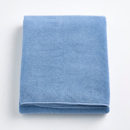 Folded denim blue Signature bath sheet in plush, absorbent cotton terry fabric with a clean hemmed edge.