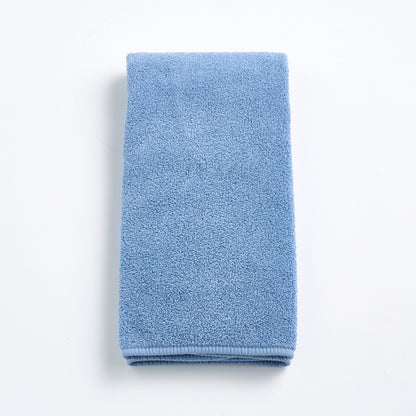 Folded denim blue cotton hand towel with a textured terry cloth finish on a white background.