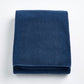 Folded indigo blue Signature bath sheet made of plush, absorbent cotton terry fabric.
