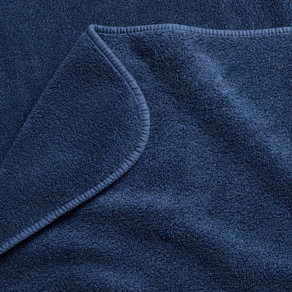 Indigo blue Signature washcloth featuring a soft, absorbent cotton terry texture and a finished hemmed edge.