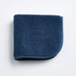 Indigo blue Signature washcloth in soft, textured cotton terry with a rounded corner and finished fabric trim.