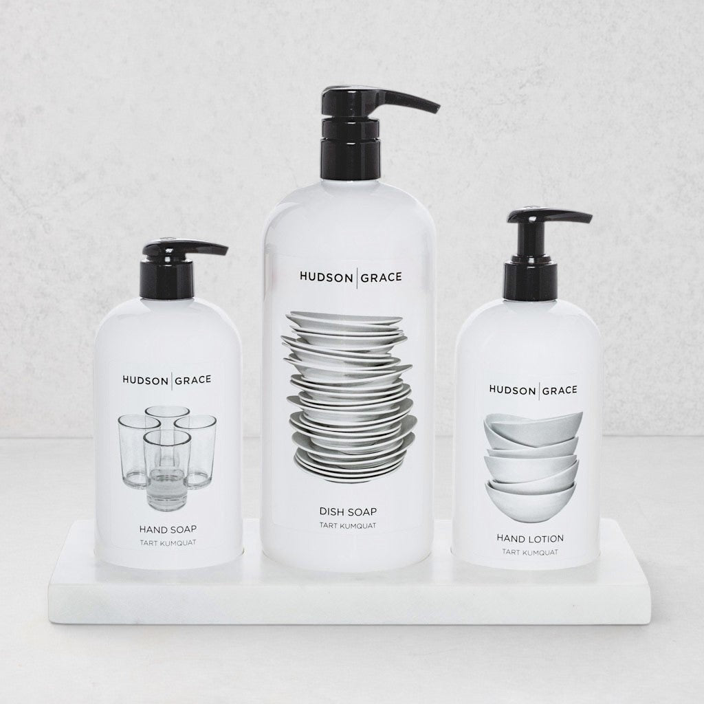 Hudson Grace kitchen set with dish soap, hand soap, and hand lotion in white bottles on a creamy white marble tray.
