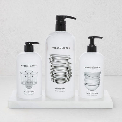 Hudson Grace kitchen set with dish soap, hand soap, and hand lotion in white bottles on a creamy white marble tray.
