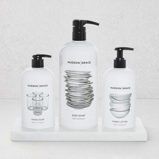 Hudson Grace kitchen set with dish soap, hand soap, and hand lotion in white bottles on a creamy white marble tray.
