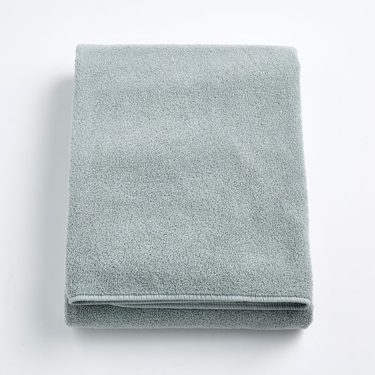Folded mist blue Signature bath sheet in plush, absorbent cotton terry fabric on a white background.