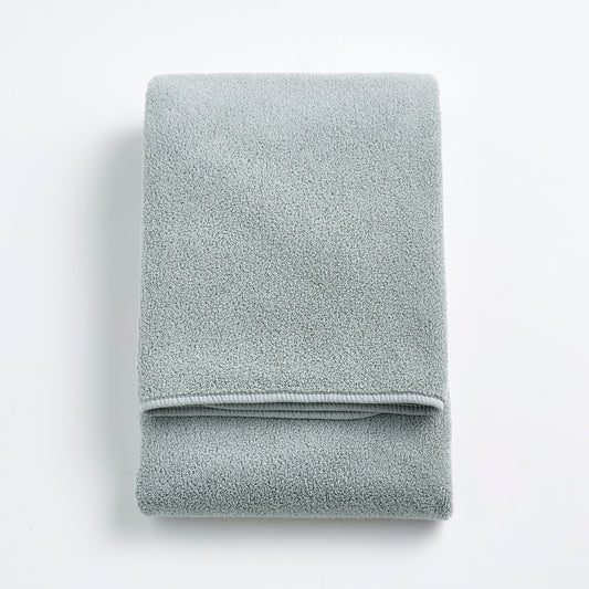 Folded mist blue Signature bath towel with a soft, plush cotton texture on a white background.