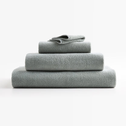 Stacked Mist Blue HG Signature zero-twist cotton bath towels with piped edges on a white background.