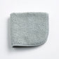 Mist blue Signature washcloth in soft, textured cotton terry with a finished fabric edge on a white background.