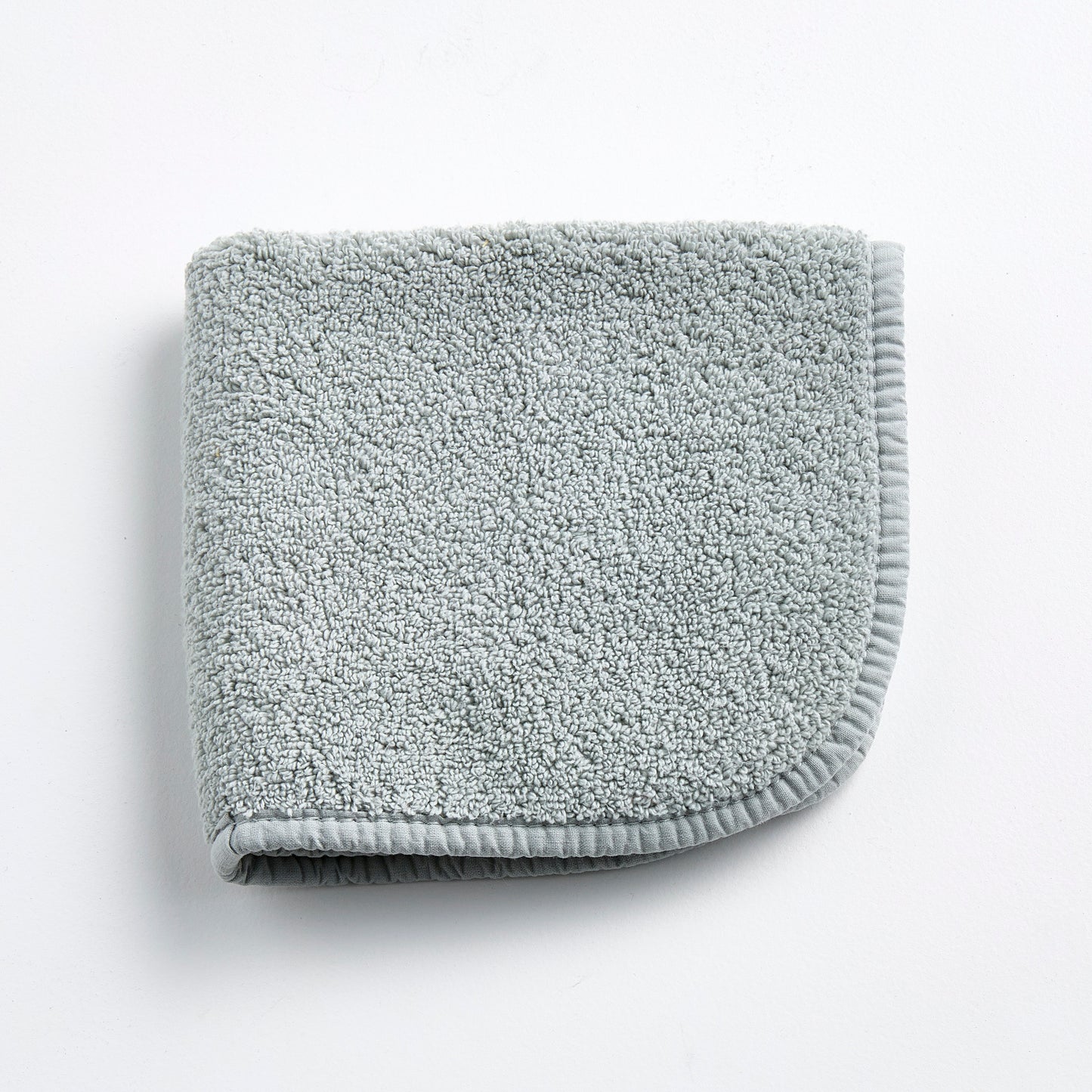 Mist blue Signature washcloth in soft, textured cotton terry with a finished fabric edge on a white background.