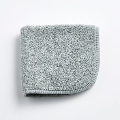 Mist blue Signature washcloth in soft, textured cotton terry with a finished fabric edge on a white background.