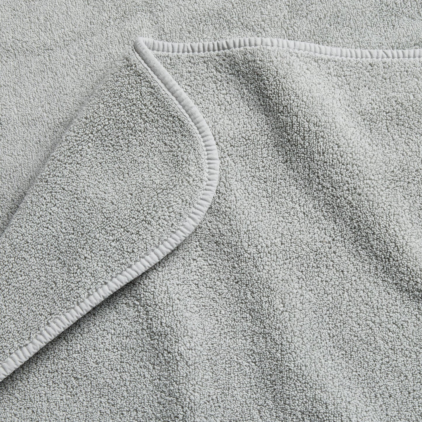 Mist blue Signature hand towel with a soft, plush cotton terry texture and a finished hemmed edge.