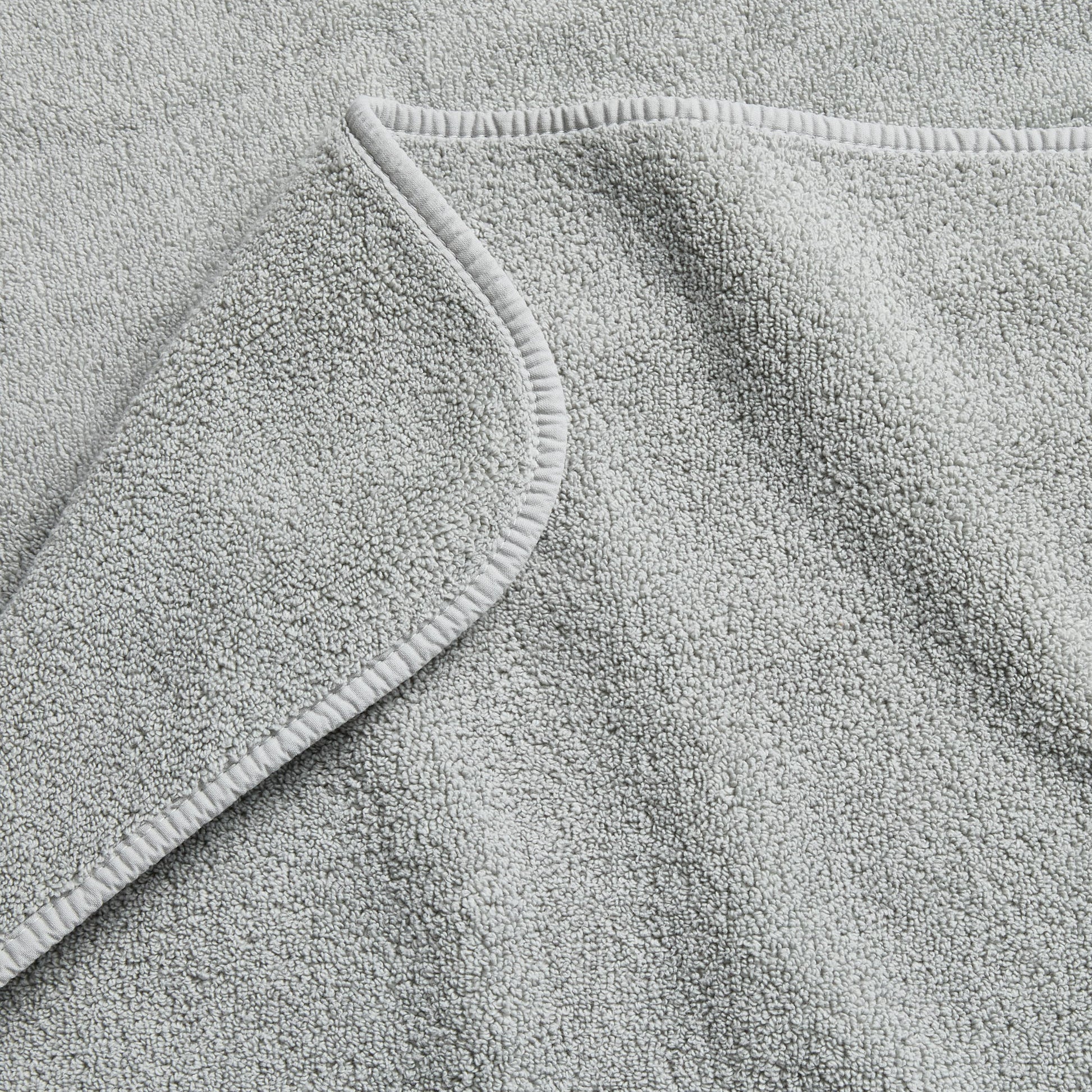 Mist blue Signature hand towel with a soft, plush cotton terry texture and a finished hemmed edge.