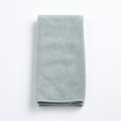 Folded mist blue Signature hand towel made of soft, plush cotton terry fabric on a white background.