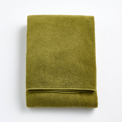 Folded olive green zero-twist cotton bath towel with matching bias piping, 30 by 56 inches.