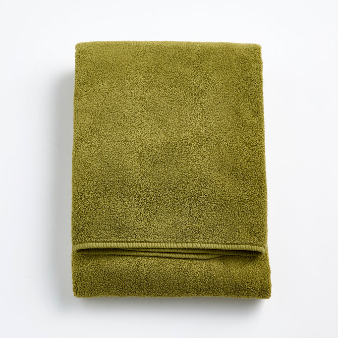 Folded olive green zero-twist cotton bath towel with matching bias piping, 30 by 56 inches.